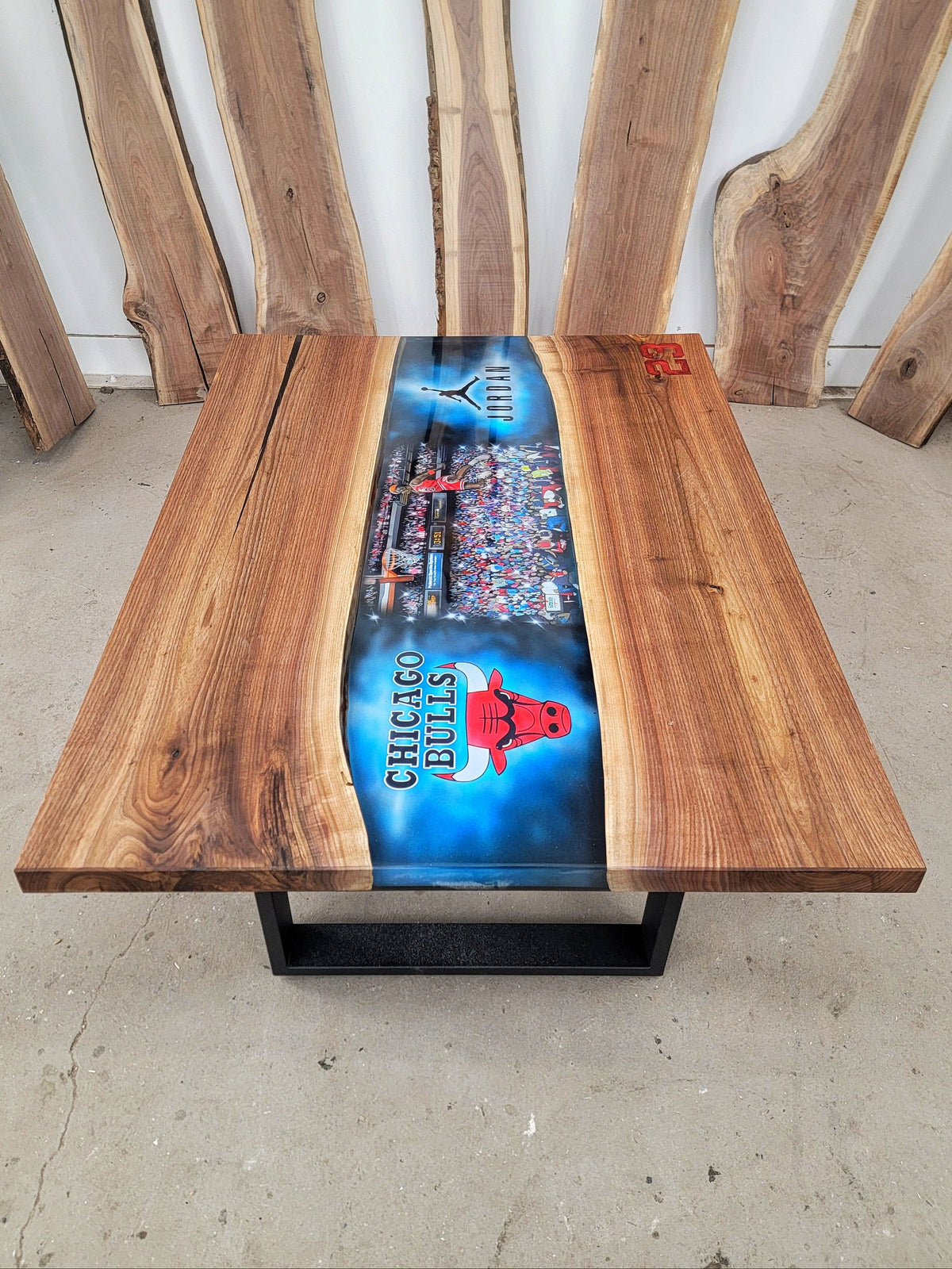 Walnut and epoxy coffee table with central airbrushed designs of Chicago Bulls logo, Michael Jordan logo, and Michael Jordan dunking a basketball with a cheering crowd behind him