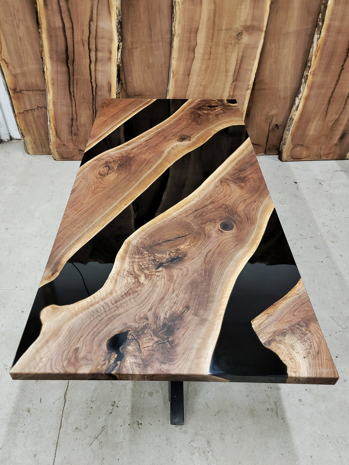 walnut wooden table with three black epoxy rivers built by Backyard Resin