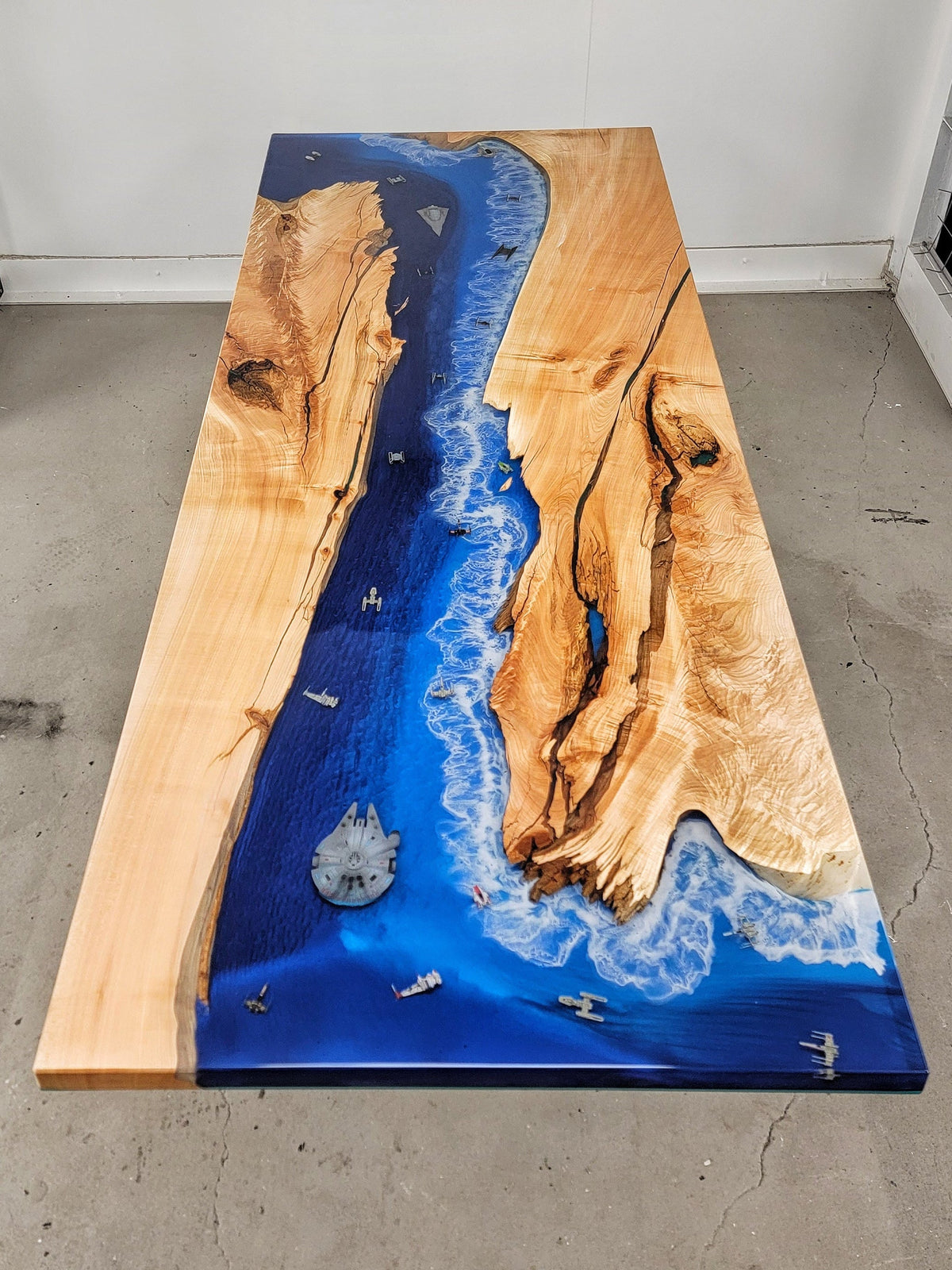 Maple wooden bar top with ocean-style resin as central river with Star Wars ships embedded