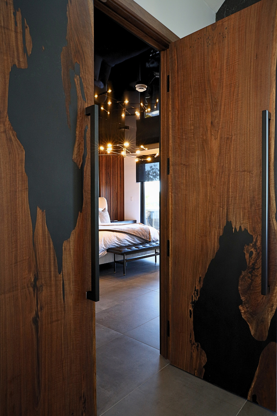 Custom walnut wood and epoxy matchbook doors with large metal handles, made and installed by Backyard Resin.