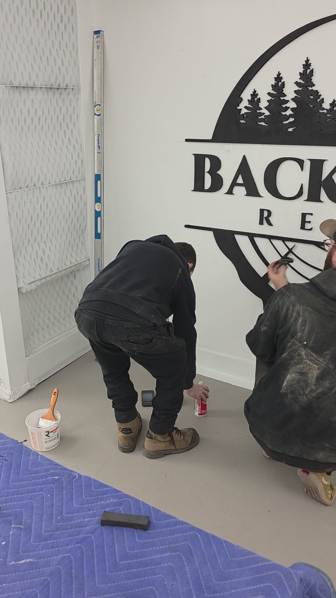video of the backyard resin shop crew installing the backyard resin logo on a white wall