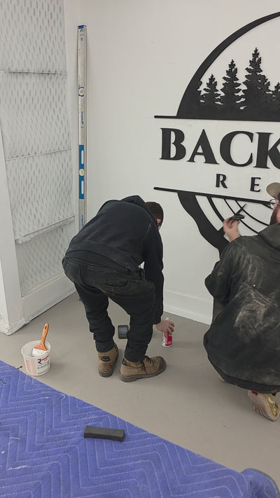 video of the backyard resin shop crew installing the backyard resin logo on a white wall